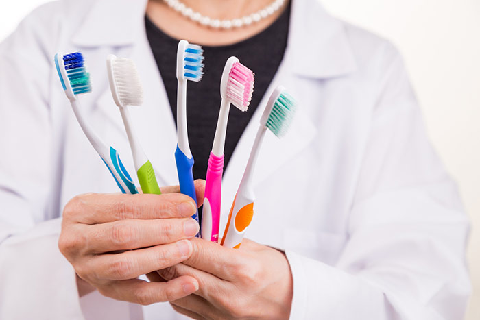 Dentist holding toothbrushes