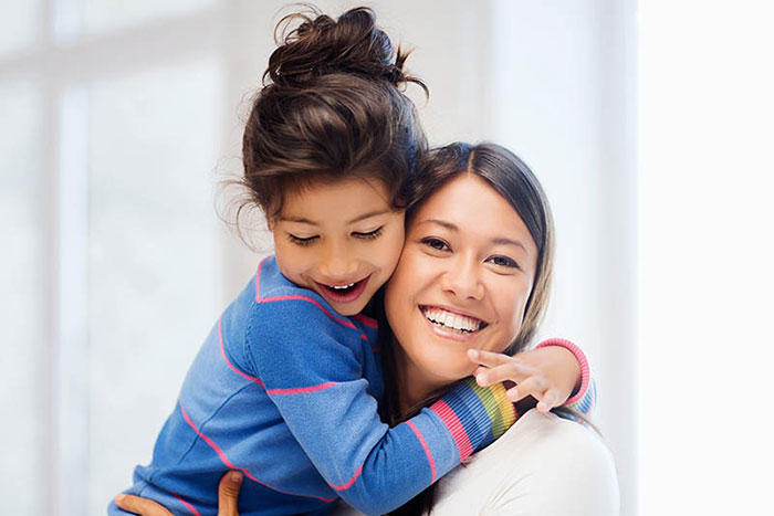 Mother holding her daughter and smiling