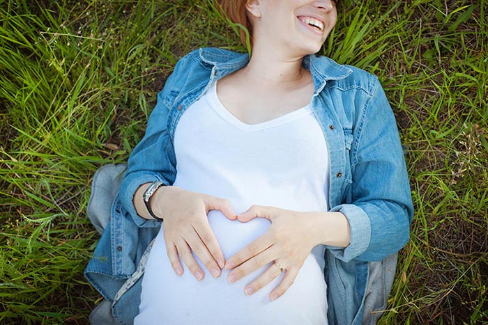 Pregnant woman laying in grass