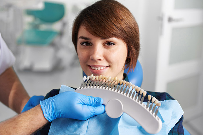 Woman holding tooth color samples