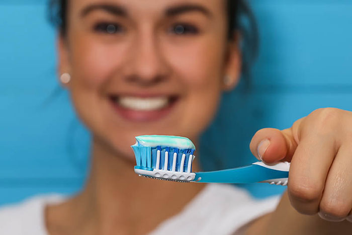 Woman holding a toothbrush with toothpaste