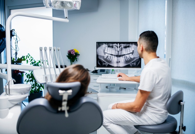 A dentist discussing an X-ray with a patient, for a restorative dental treatment in Homewood, IL